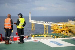 Workers working off shore discussing a RIDDOR report