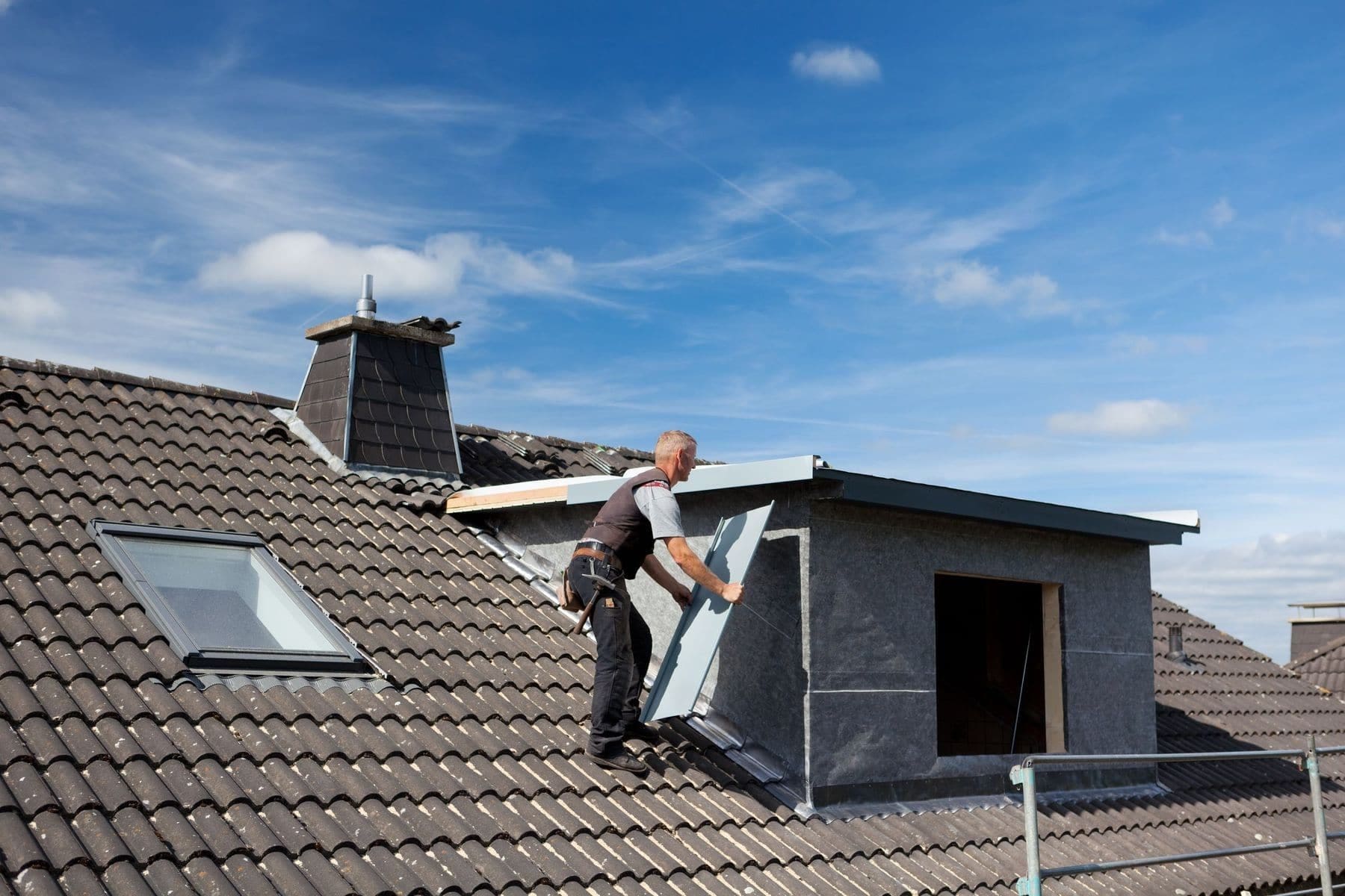 21259960 - roofer carrying a metal piece through the rooftop to the dormer wall Roofer CPD courses