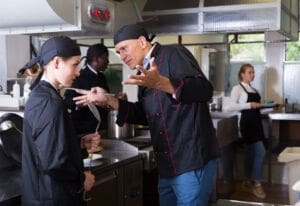 Stressed hospitality chef shouting at employee