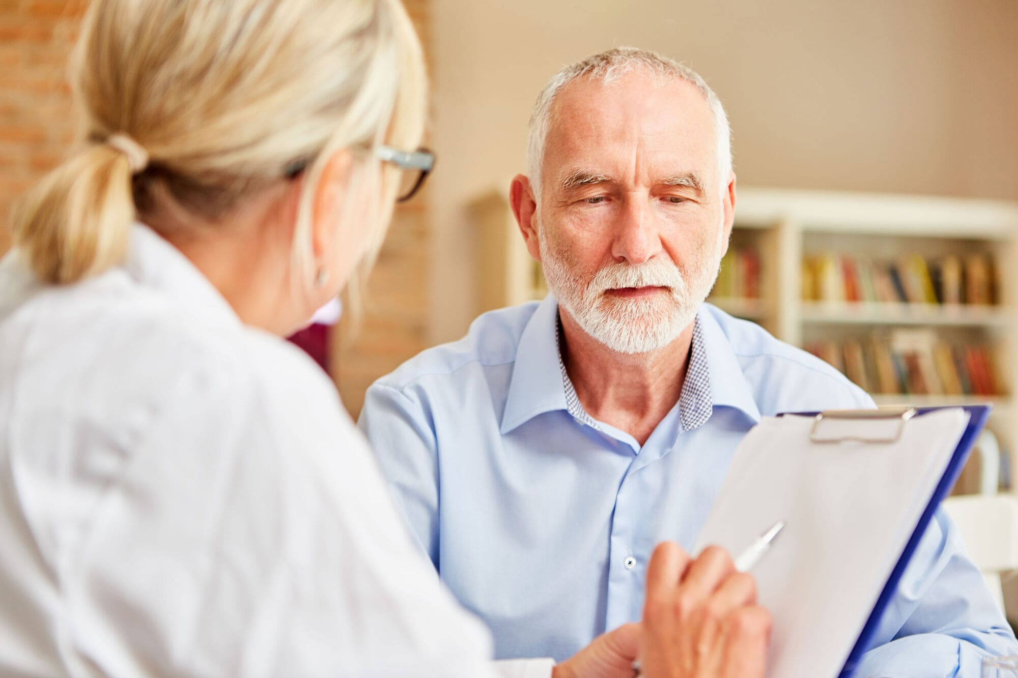 Doctor Going Through Health Surveillance Questionaires With Patient, Part of Occupational Health Assessment