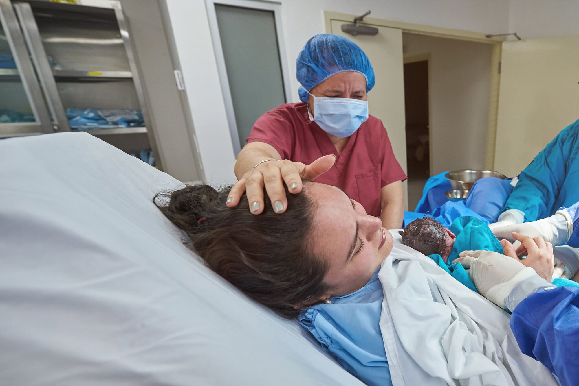 Midwife assisting in c-section delivery
