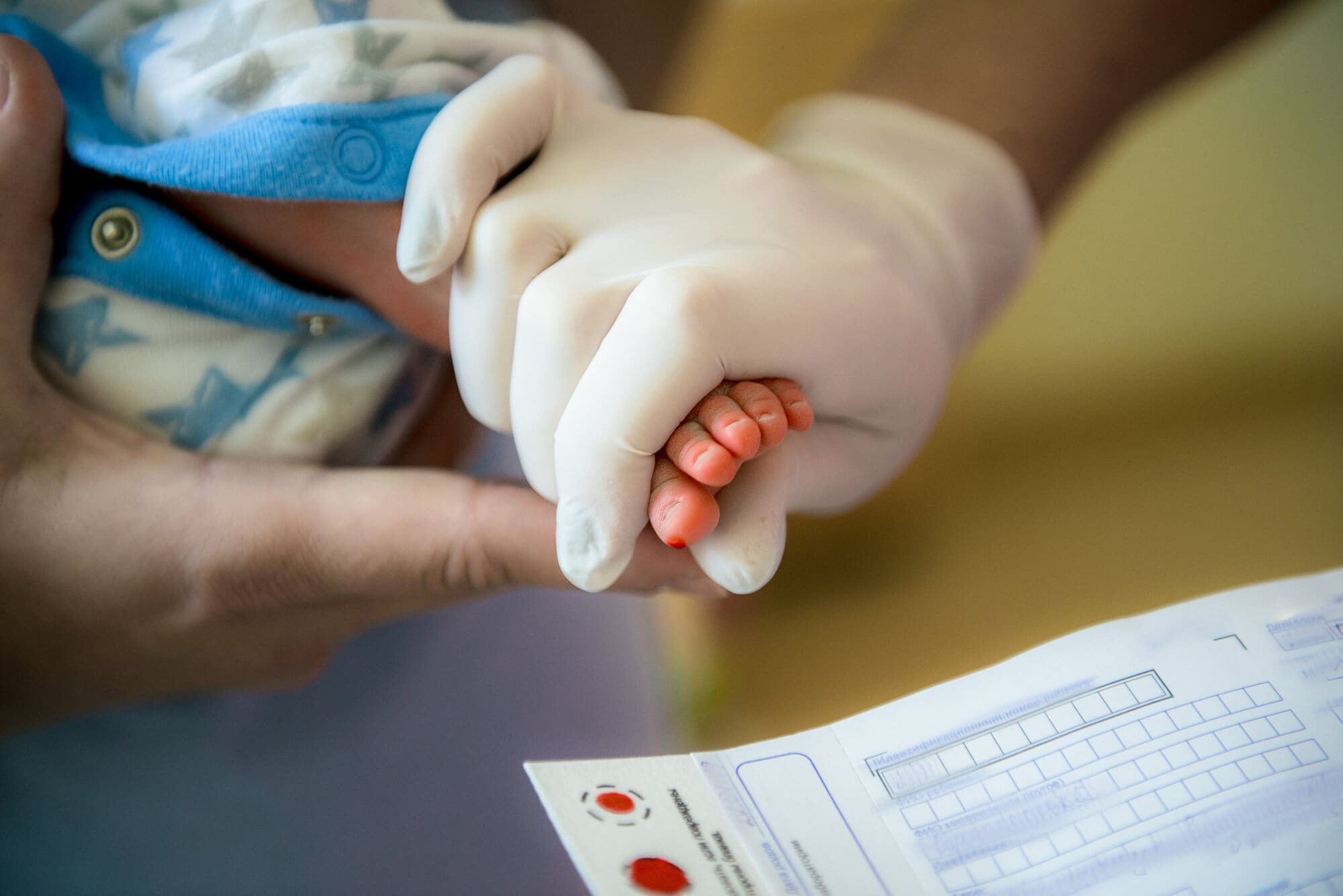 Midwife taking newborn baby's blood