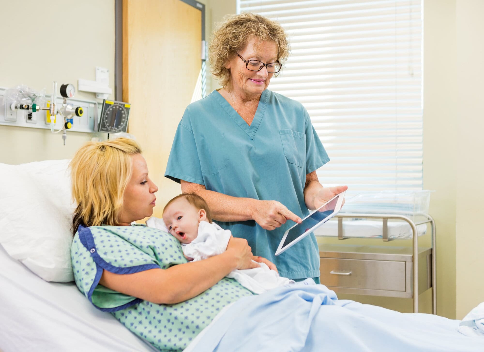 Neonatal midwife talking to mother while holding her baby