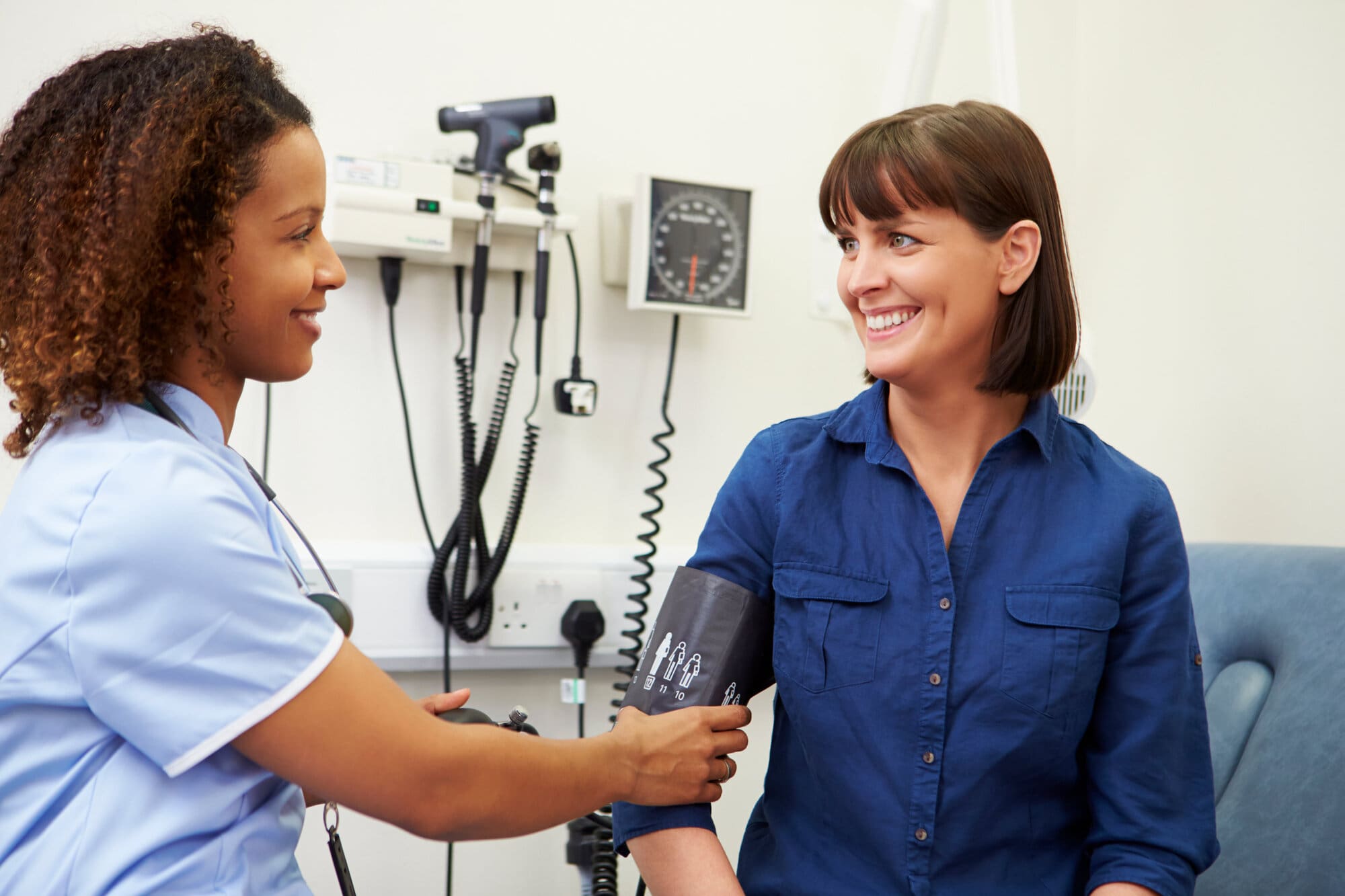 Nurse taking blood pressure of patient at GP surgery