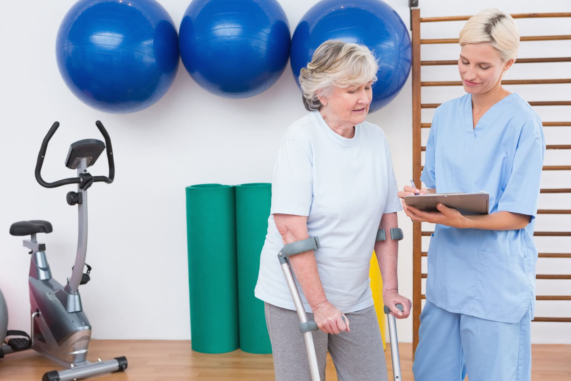 Rehabilitation therapist working in care home with elderly lady