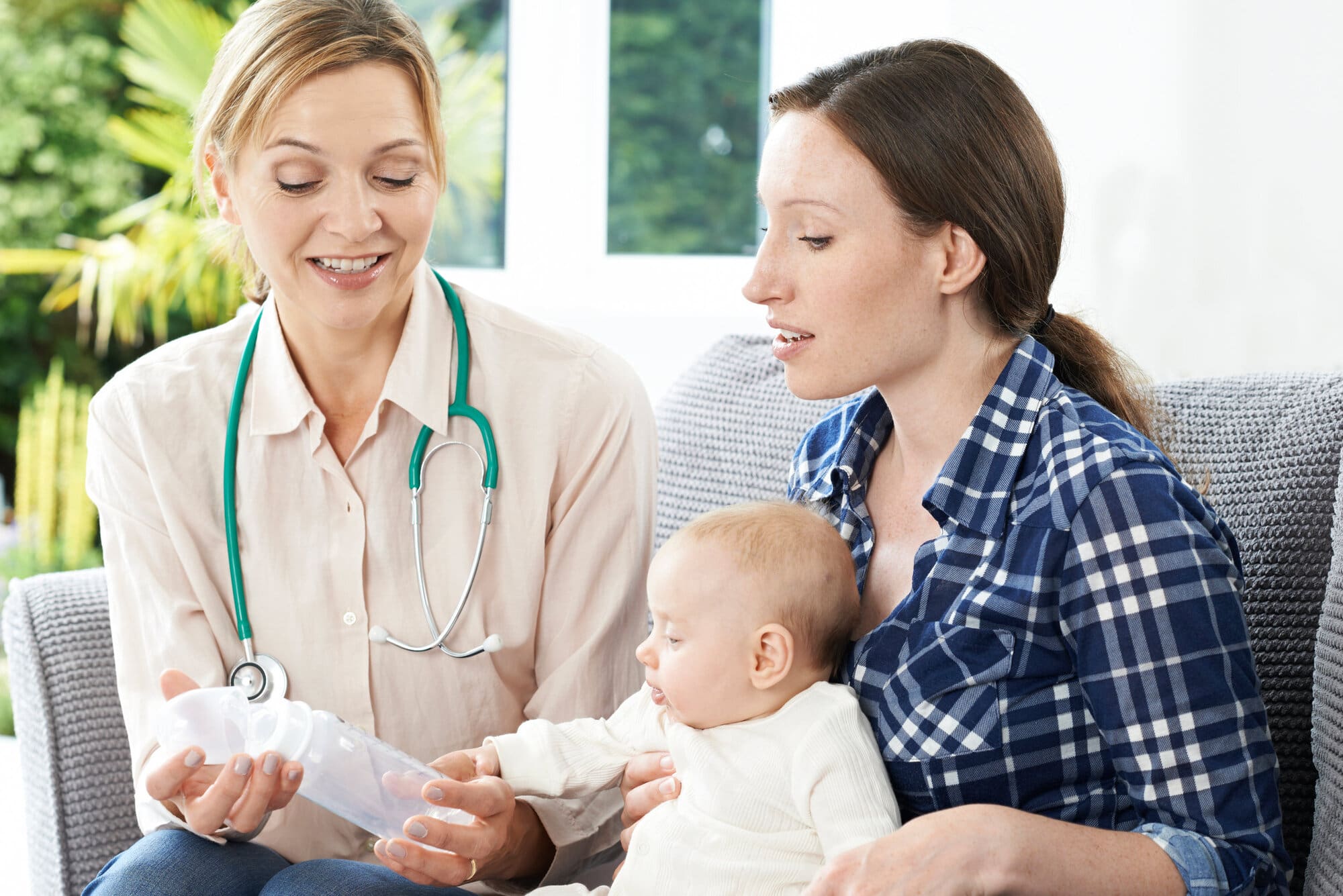 Health visitor assisting new mother and her baby