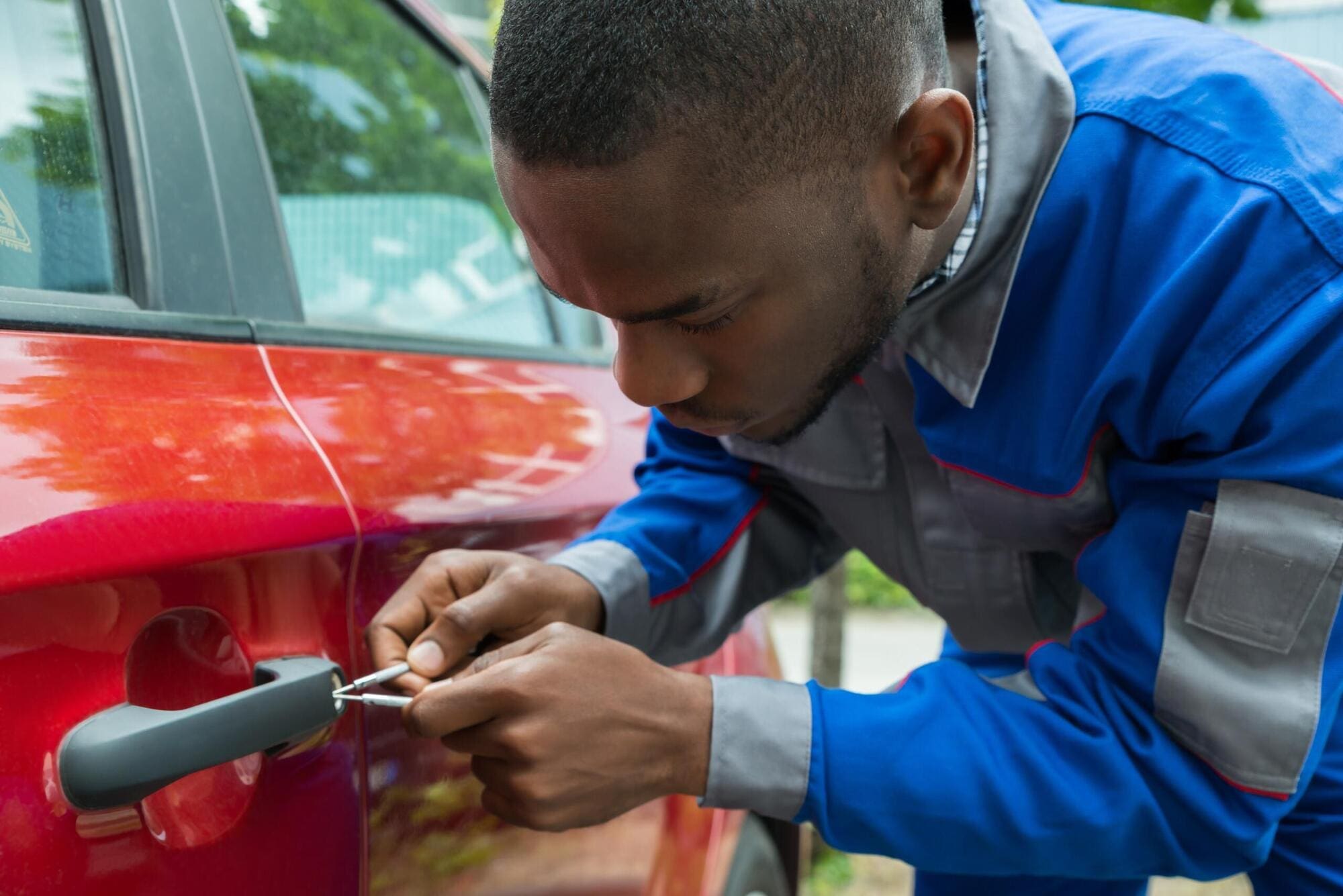 Locksmith working on vehicle in the outdoors