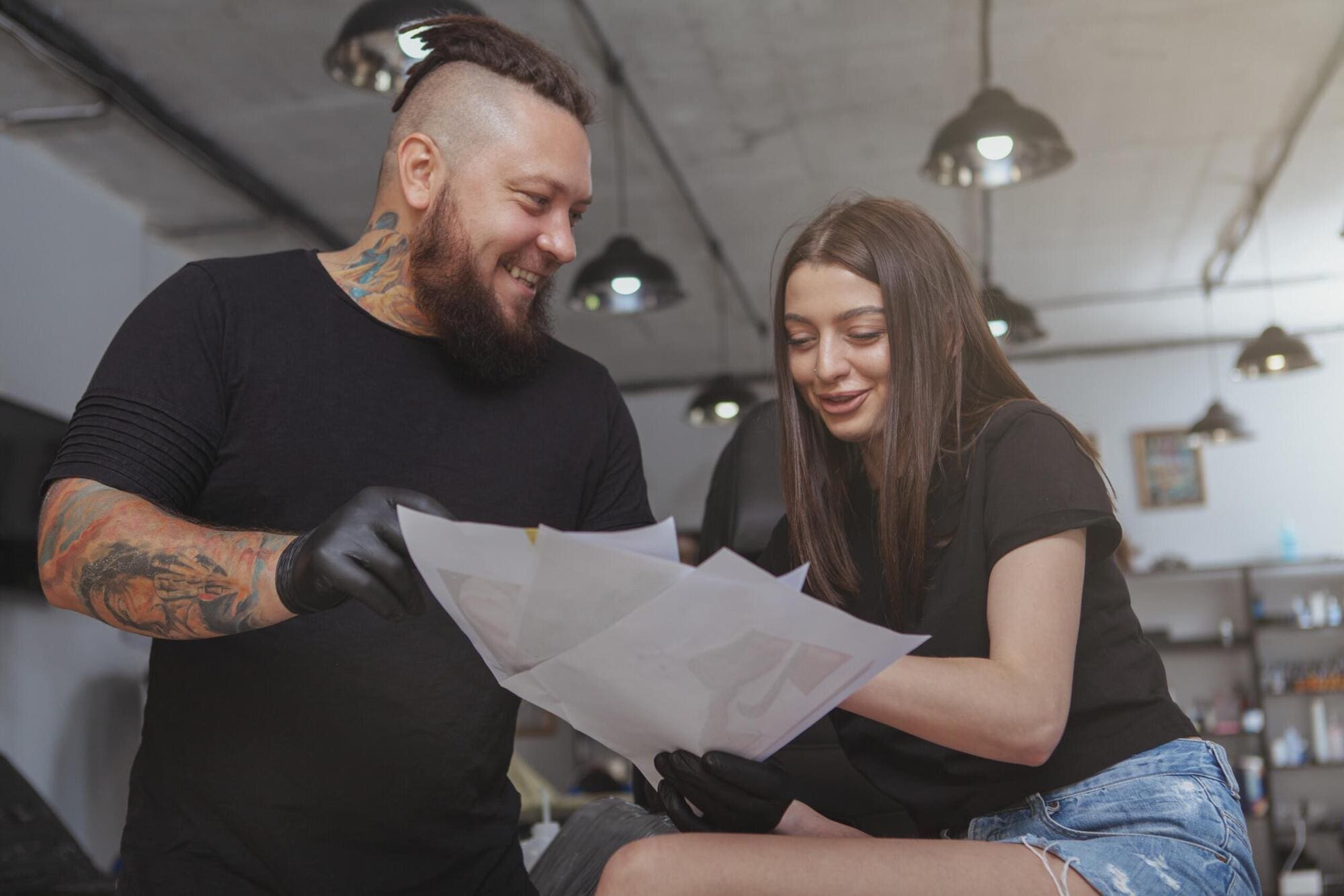 Tattoo artist with client choosing design