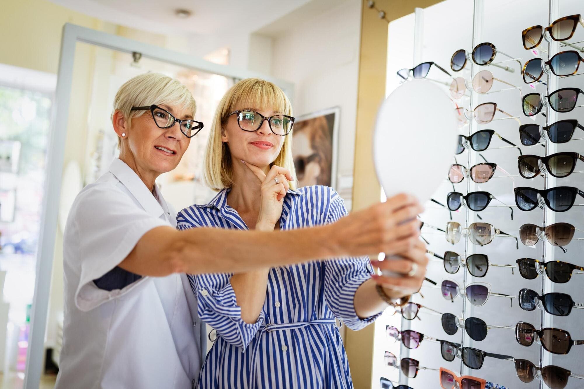 Optician helping customer find correct glasses type