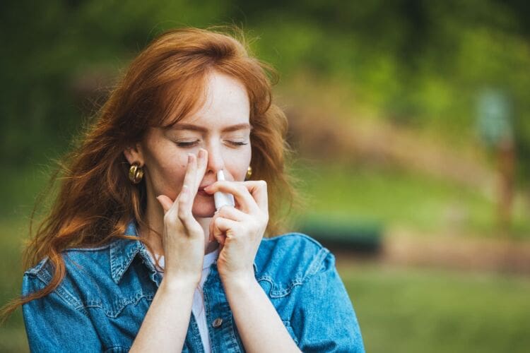 Woman with anaphylaxis blowing nose